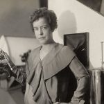 Vintage woman with scientific instrument, representing women in HVAC, in a studio setting with laboratory equipment.